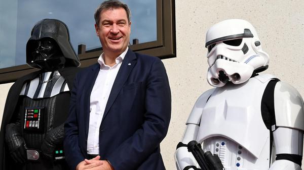 Markus Söder (Mitte), selbst Star-Wars-Fan, ließ sich mit Darth Vader (links) und einem Sturmtruppler (rechts) abbilden.
