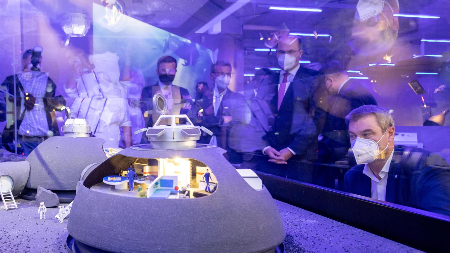 Bei der Eröffnung des Zukunftsmuseums  betrachtet Ministerpräsident Markus Söder das Modell eine  Mondstation der NASA, die noch in diesem Jahrzehnt realisiert werden soll. Leben im Weltall? Eine Möglichkeit wohl nur für wenige Menschen.