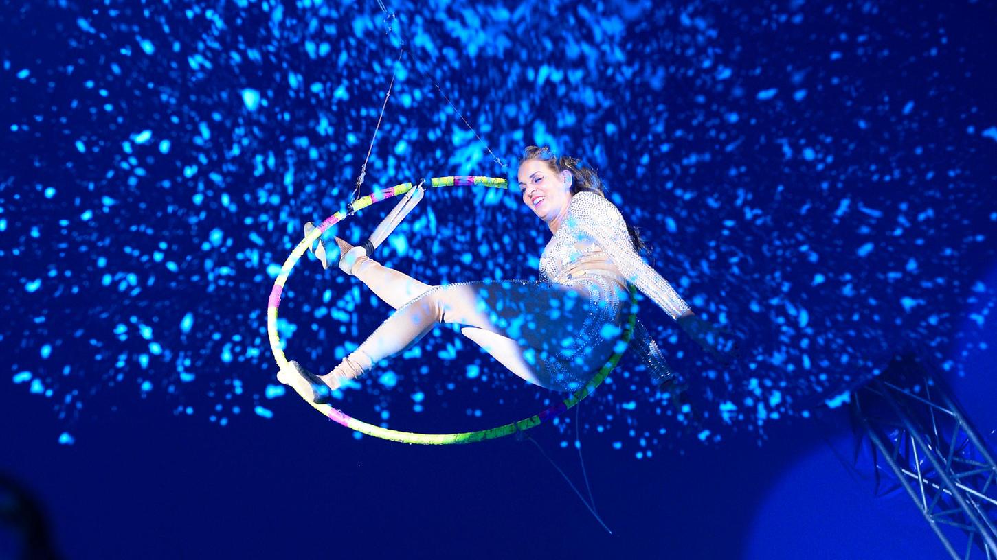 Hohe circensische Kunst im Reifen in luftiger Höhe: Magie in der Manege beim Circus Renz. Hohe circensische Kunst im Reifen in luftiger Höhe: Magie in der Manege beim Circus Renz.
