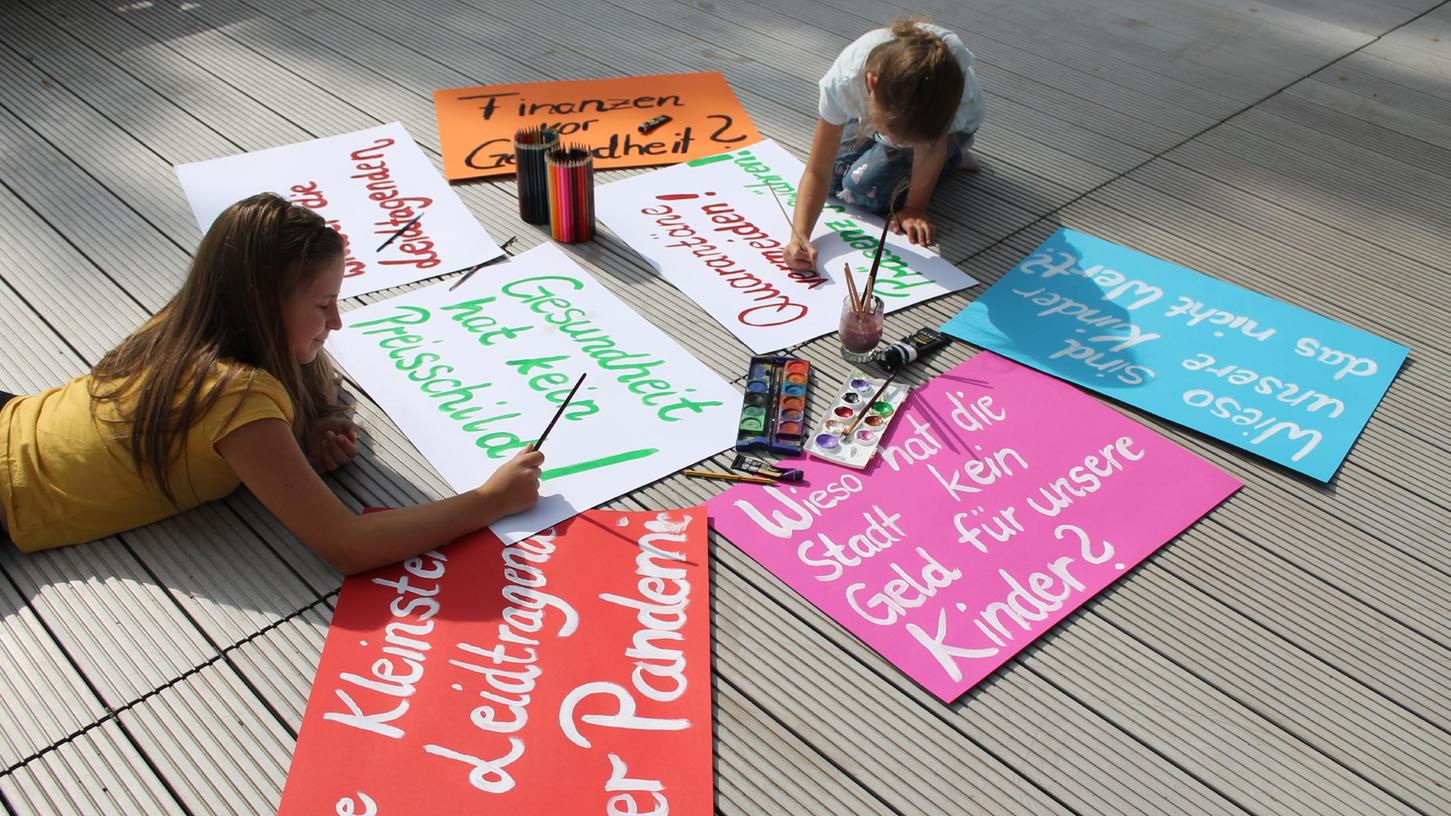 Kara (11) und Nina (7), die Töchter von Dorothea Wicke, bereiten Transparente für eine Demonstration zur Stadtratssitzung in Höchstadt vor. Die Teilnehmenden fordern die Anschaffung von Luftfiltern gegen das Coronavirus in beiden Grundschulen.