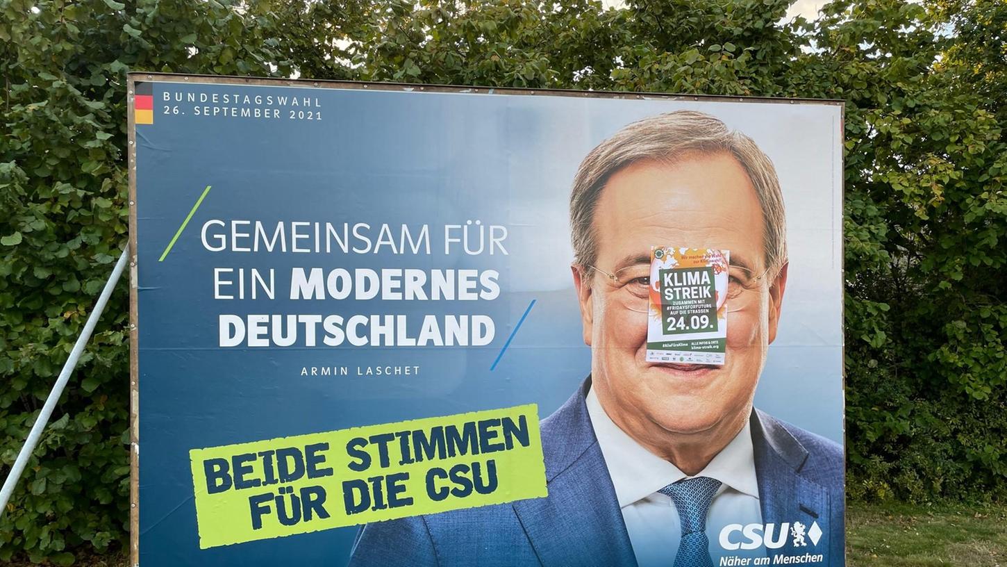 Auch ein Großplakat mit CSU-Kanzlerkandidat Armin Laschet haben die Aktivisten überklebt, um für den Klimastreik am 24. September zu werben.