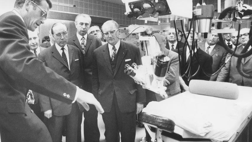 Dr. Gerhard Barthelmeß, Chef der Augenklinik (links), erklärt die moderne technische Einrichtung. Interessiert hören Dr. Thoma (3. von links) und Minister Pirkl (6. von links) zu. Hier geht es zum Kalenderblatt vom 26. September 1971: Das erste Hochhaus für Kranke.