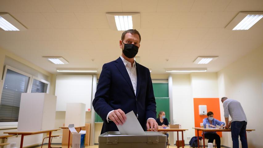 Sachsens Ministerpräsident Michael Kretschmer (CDU) wirft bei der Stimmabgabe zur Bundestagswahl im Wahllokal seinen Stimmzettel in eine Wahlurne in Dresden.
