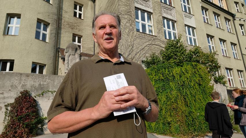 Reinhard Beck hat seit 1976 keine Wahl in Nürnberg verpasst. Die amtliche Wahlbenachrichtigung hält er fest in seinen Händen, als er die Grolandstraße entlang läuft. Erst kurz vor dem Schuleingang fällt dem 67-Jährigen auf, dass er seine Maske vergessen hat. Wenig später hat aber auch er abgestimmt. Ein Wahlhelfer hat ihm einen Mund-Nase-Schutz gegeben.
