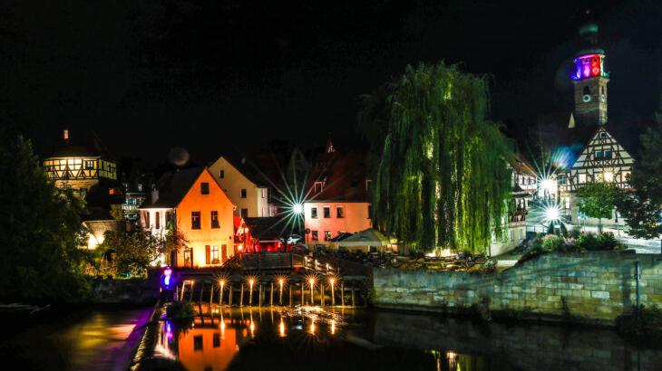 Die Reichelsche Schleif an der Wasserbrücke erstrahlt zurzeit in rotem Licht. Auch die Gebäude dahinter, wie der Judenturm, sind beleuchtet, um Tiefe zu schaffen. Die Reichelsche Schleif an der Wasserbrücke erstrahlt zurzeit in rotem Licht. Auch die Gebäude dahinter, wie der Judenturm, sind beleuchtet, um Tiefe zu schaffen.
