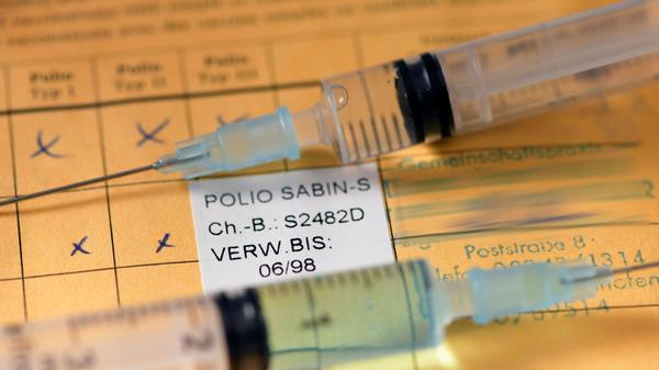 08.09.2020, Impfen, Symbolbild, ein Impfpass liegt auf dem Tisch mit zwei Spritzen. 08.09.2020, Impfen Symbolbild Impfp