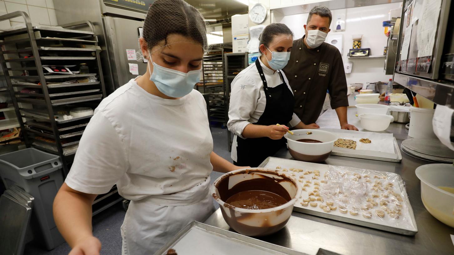 Konditormeister Martin Rößler mit seinen Auszubildenden Anna-Lena Geyer und Janina Meister bei der Gebäckherstellung.
Konditormeister Martin Rößler mit seinen Auszubildenden Anna-Lena Geyer und Janina Meister bei der Gebäckherstellung.