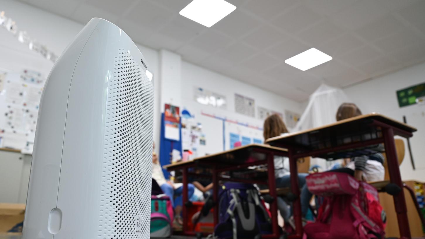 Ein Luftfilter steht in einem Grundschul-Klassenzimmer. Viele Kommunen haben als Sachaufwandsträger solche Geräte angeschafft.