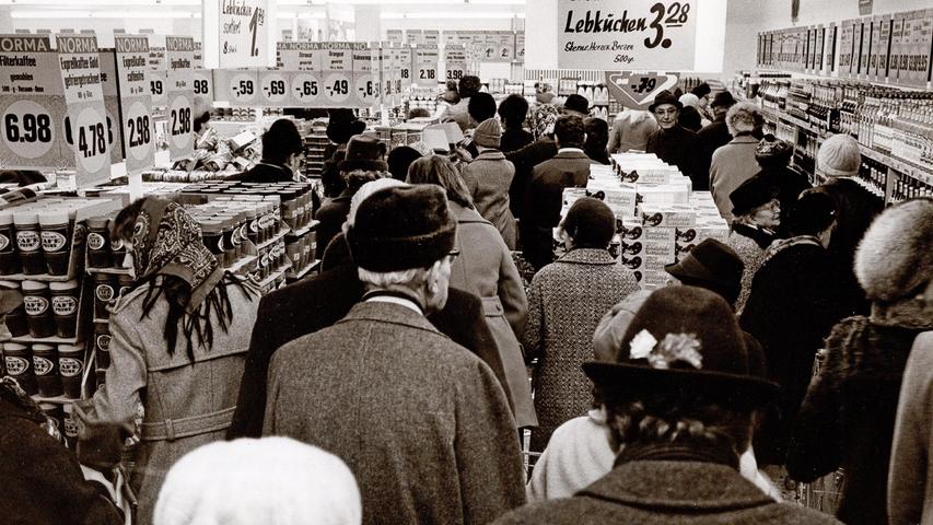 Menschen stehen Schlange, um 1970 Wenn etwas Begehrtes besonders günstig angeboten wurde, stand der ganze Verkaufsraum voll mit Kundinnen und Kunden