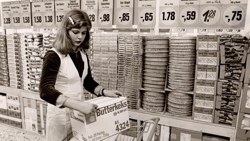 Kuchen und Kekse, um 1970 Die Waren in den Norma-Läden wurden nicht ausgepackt und in Regale einsortiert, sondern in Lieferkartons zum Verkauf angeboten. Das sparte Arbeitszeit, was unter anderem niedrigste Preise ermöglichte.