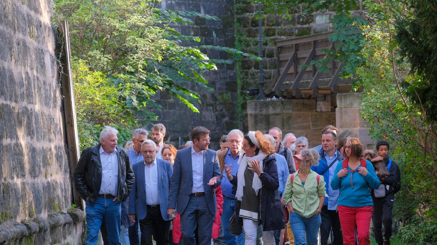 Nürnbergs Oberbürgermeister Marcus König (3.v.li.) im Gespräch mit Bürgern auf dem Weg durch den Stadtgraben unterhalb der Kaiserburg.