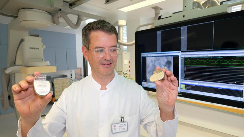 Dr. Karsten Pohle, Chefarzt der Kardiologie am Krankenhaus Martha-Maria Nürnberg, zeigt zwei verschiedene Arten von Rhythmusgeräten für das Herz: links der größere Defibrillator für zu schnelle Rhythmusstörungen, rechts der Herzschrittmacher für den zu langsamen Herzschlag.
