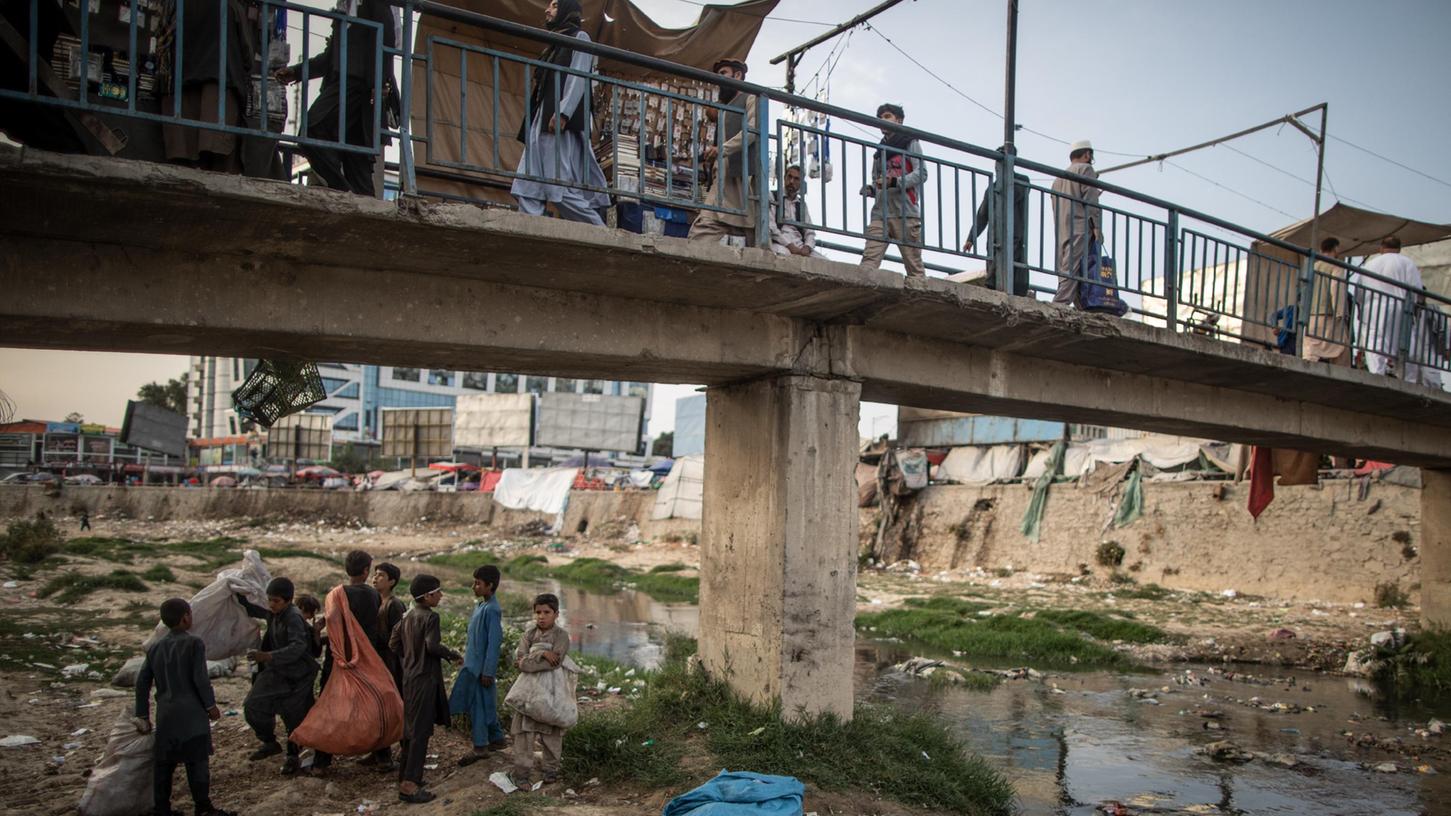 Junge Afghanen sammeln Plastikflaschen aus einem vermüllten Fluss in Kabul, um sie als Recyclingmaterial zu verkaufen. Viele von ihnen leben auf der Straße.  