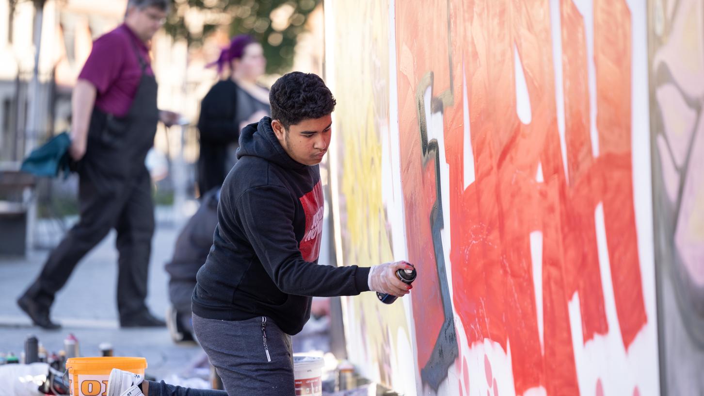 Mehr Farbe für die Stadt: Einer der Streetart-Sprayer nimmt sich seine Bauzaun-Fläche vor. Mehr Farbe für die Stadt: Einer der Streetart-Sprayer nimmt sich seine Bauzaun-Fläche vor.