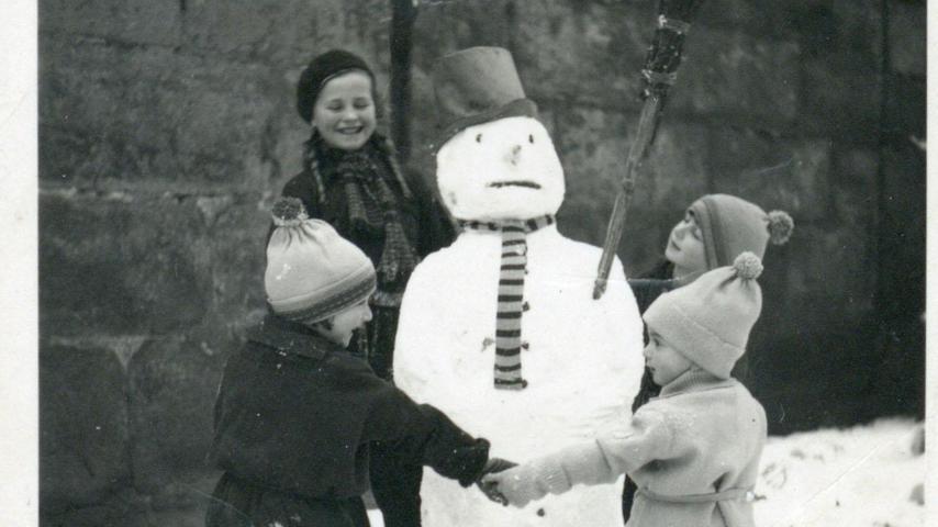 Erlangen, im Winter 1937: Erich, Hildegard und Hannelore Benesi tanzen mit einem Nachbarmädchen um einen Schneemann. 1943 ermordeten die Nazis die Benesi-Kinder gemeinsam mit ihren Eltern Jakob und Gottliebe in Auschwitz.
Erlangen, im Winter 1937: Erich, Hildegard und Hannelore Benesi tanzen mit einem Nachbarmädchen um einen Schneemann. 1943 ermordeten die Nazis die Benesi-Kinder gemeinsam mit ihren Eltern Jakob und Gottliebe in Auschwitz.