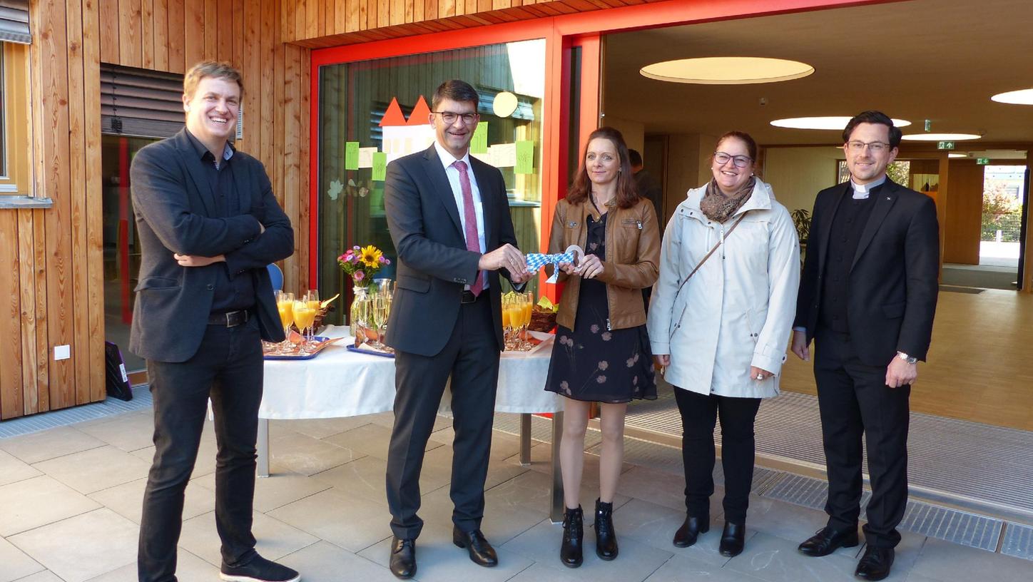 Bürgermeister Alexander Dorr hat symbolisch den Schlüssel an Kita-Leiterin Christine Emmerling übergeben; links Planer Michael Kühnlein junior, rechts Geschäftsführerin Katharina Appler und Pfarrer Alexander Proksch.
Bürgermeister Alexander Dorr hat symbolisch den Schlüssel an Kita-Leiterin Christine Emmerling übergeben; links Planer Michael Kühnlein junior, rechts Geschäftsführerin Katharina Appler und Pfarrer Alexander Proksch.