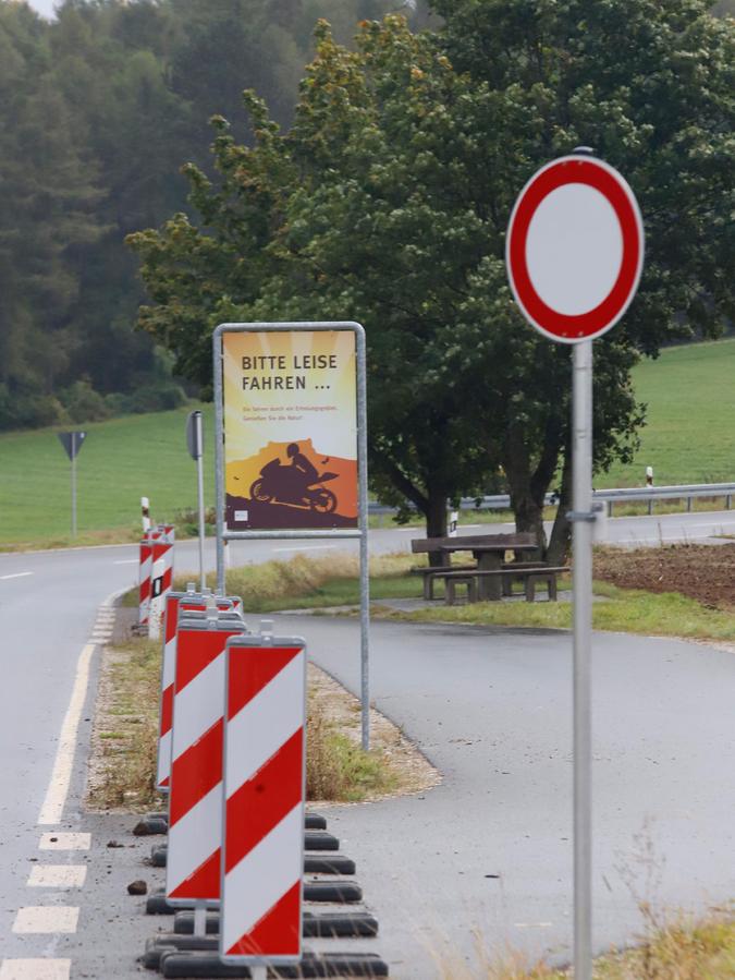 Warnbaken halten Autos vom Parken in den Parkbuchten ab. Hinweisschilder erinnern Motorradfahrer, leise zu fahren. 