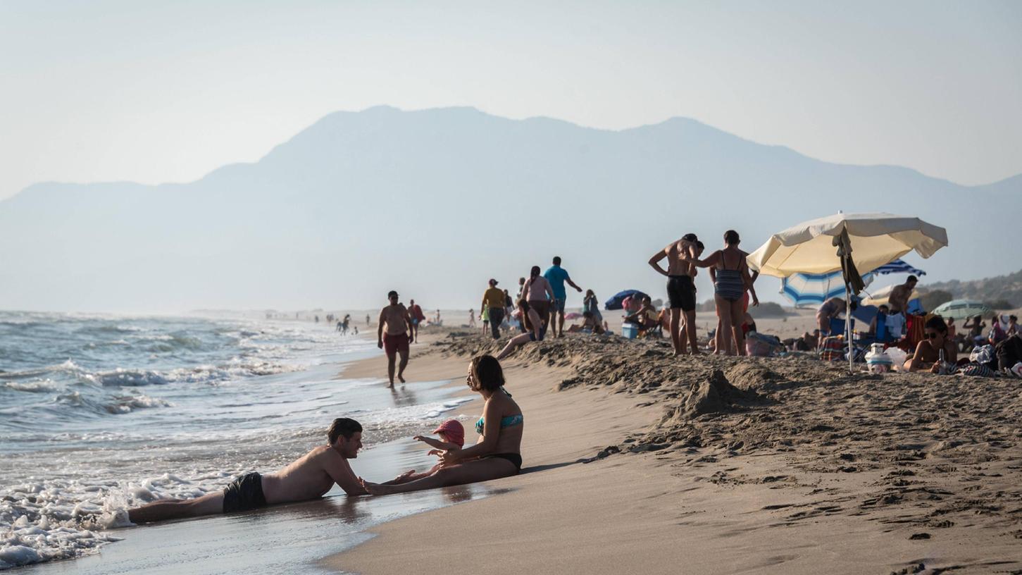 Eine Familie genießt noch im Herbst das warme Wasser am Patara-Strand bei Antalya.