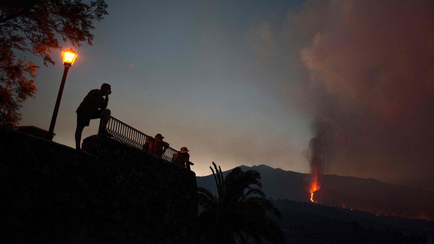 Touristen beobachten aus sicherer Entfernung den Vulkanausbruch auf der Kanareninsel La Palma.
