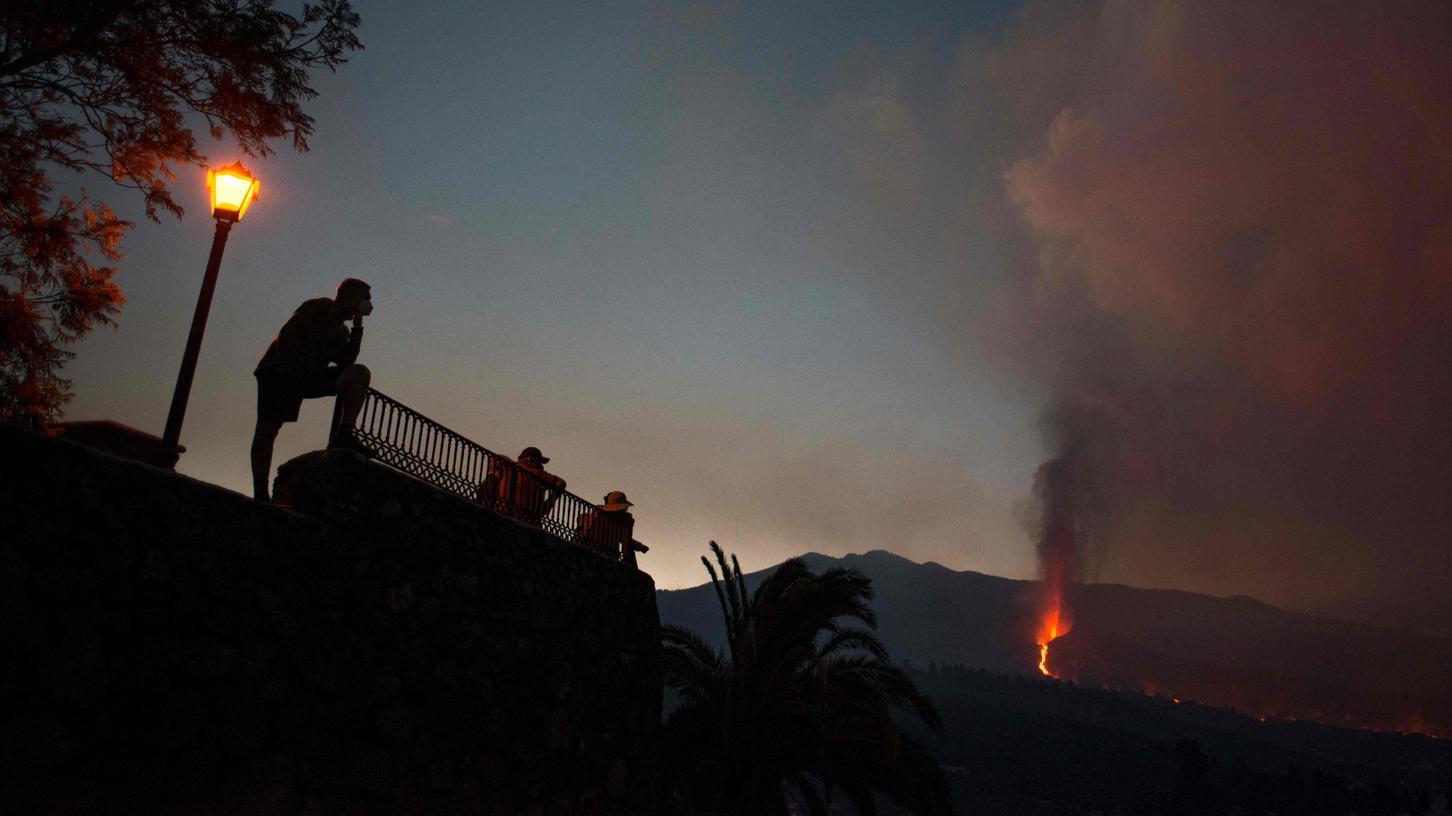 Touristen beobachten aus sicherer Entfernung den Vulkanausbruch auf der Kanareninsel La Palma.
Touristen beobachten aus sicherer Entfernung den Vulkanausbruch auf der Kanareninsel La Palma.