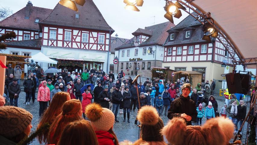 Auf dem Herzogenauracher Marktplatz gibt es in der Adventszeit nicht nur einen Weihnachtsmarkt, sondern auch den "lebendigen Adventskalender", hier mit Kantor Toni Rotter und seinem Jugendchor.