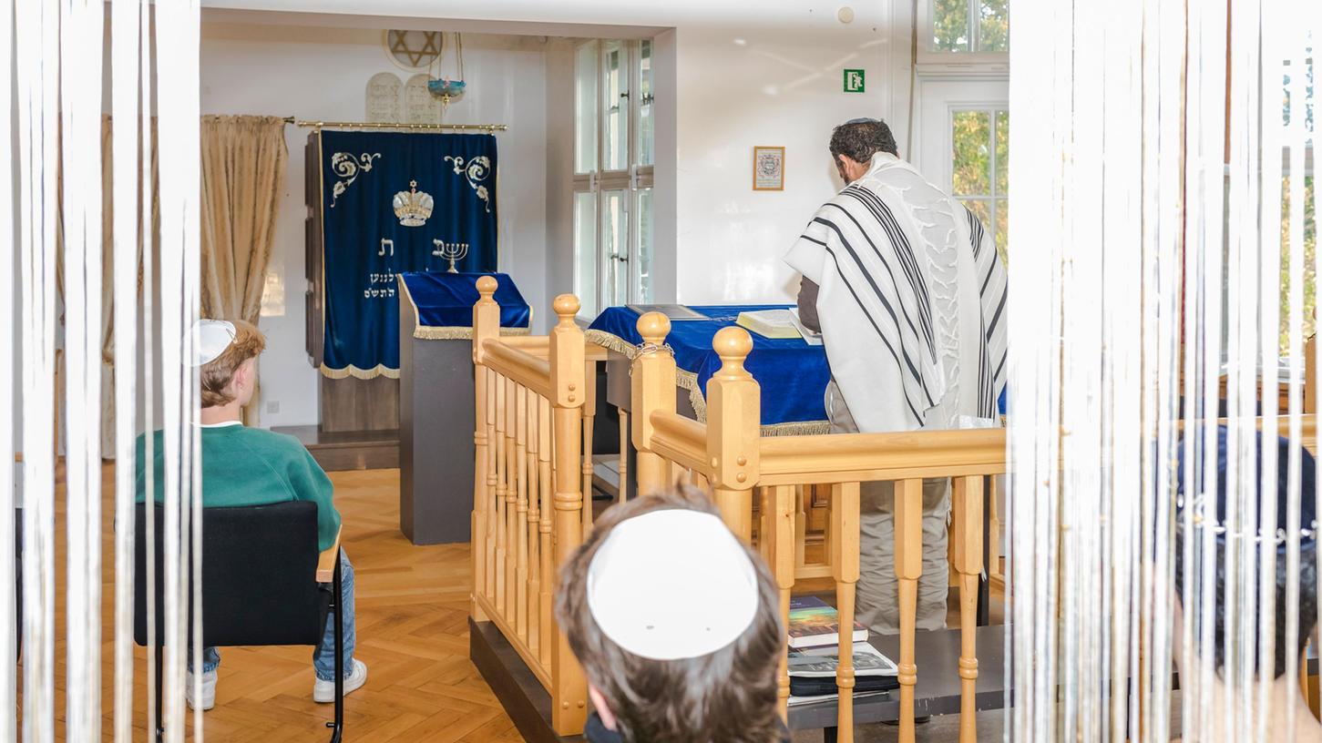 In der Synagoge tragen manche jungen Männer in Erlangen Kippa, öffentlich aber würden sie es nicht machen: Kantor Yonatan Amrani (stehend) mit Samuel (vorne) sowie Victor und Salman (rechts). 