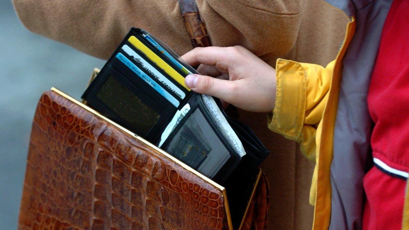 Ein Junge stiehlt eine Geldbörse aus der Handtasche. Kann man Diebstahl versichern?