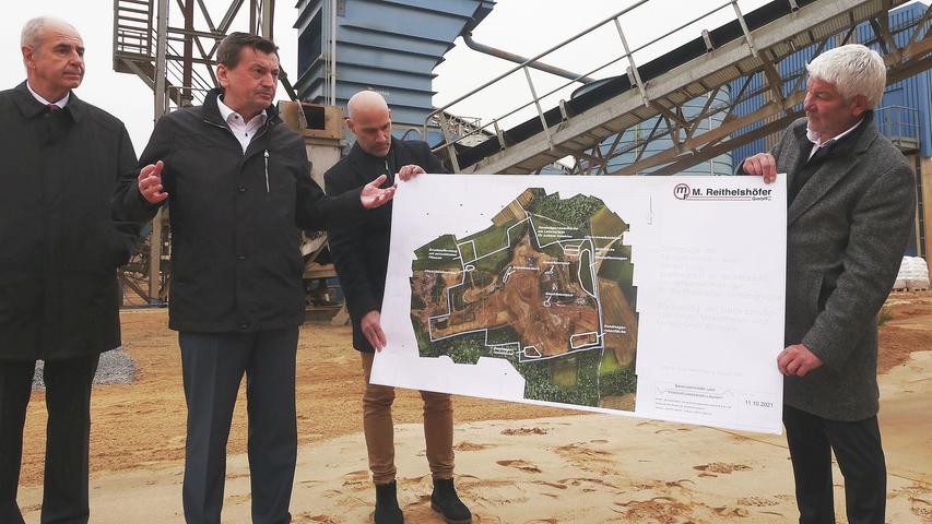 Stefan Köhn, Geschäftsführer der Reithelshöfer-Gruppe (2.v.li.) erklärt anhand des Plans, welche geschützten Bereiche für den Sandabbau derzeit tabu sind.