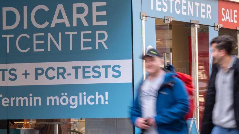 Passanten gehen an einem Corona-Testzentrum in der Münchner Innenstadt vorbei.