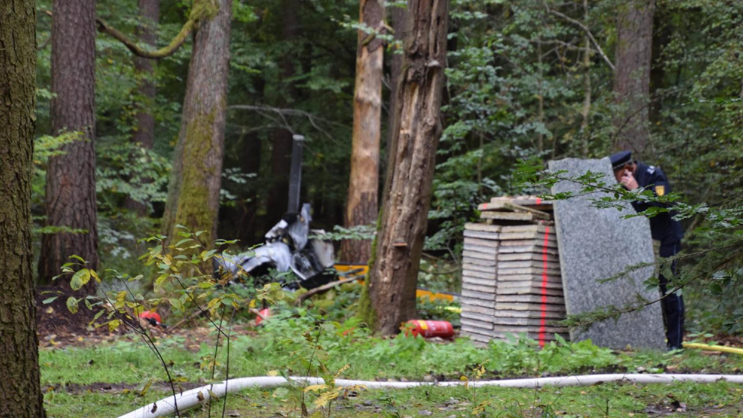 Nach dem tödlichen Hubschrauberabsturz sind die Helfer noch immer dabei die Wrackteile im Wald zu bergen.