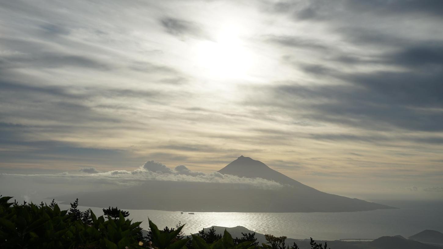 Pico auf Pico von der Insel Faial aus, die Regenwolken lösen sich auf, die Sonne bricht wieder durch.