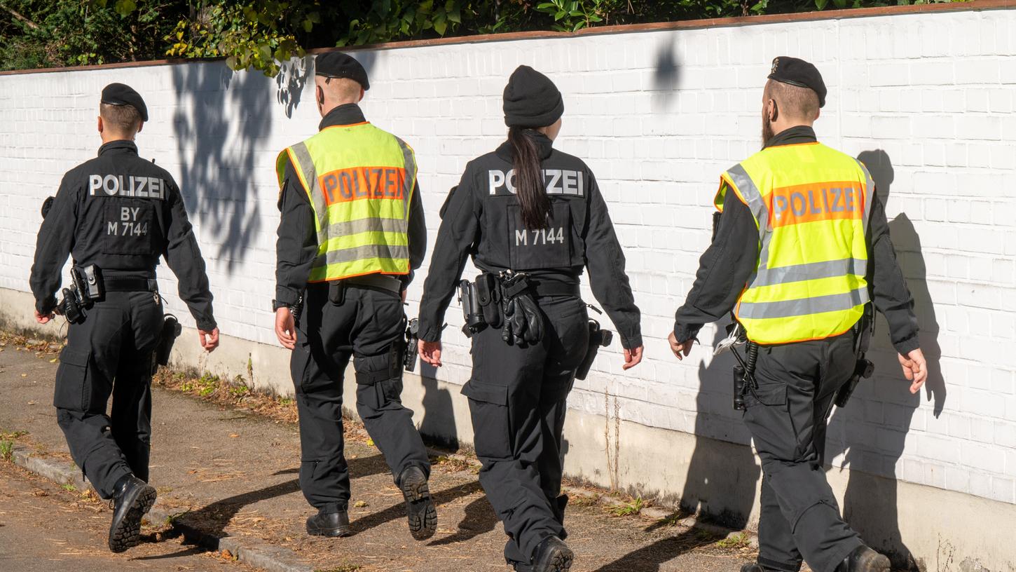 Polizisten gehen im Münchner Stadtbezirk Bogenhausen auf einer Straße entlang. Hier ist ein 14-jähriges Mädchen tot aufgefunden worden. Das Mädchen habe Gewalteinwirkungen aufgewiesen, man gehe von einem Tötungsdelikt aus, sagte ein Polizeisprecher am Sonntag