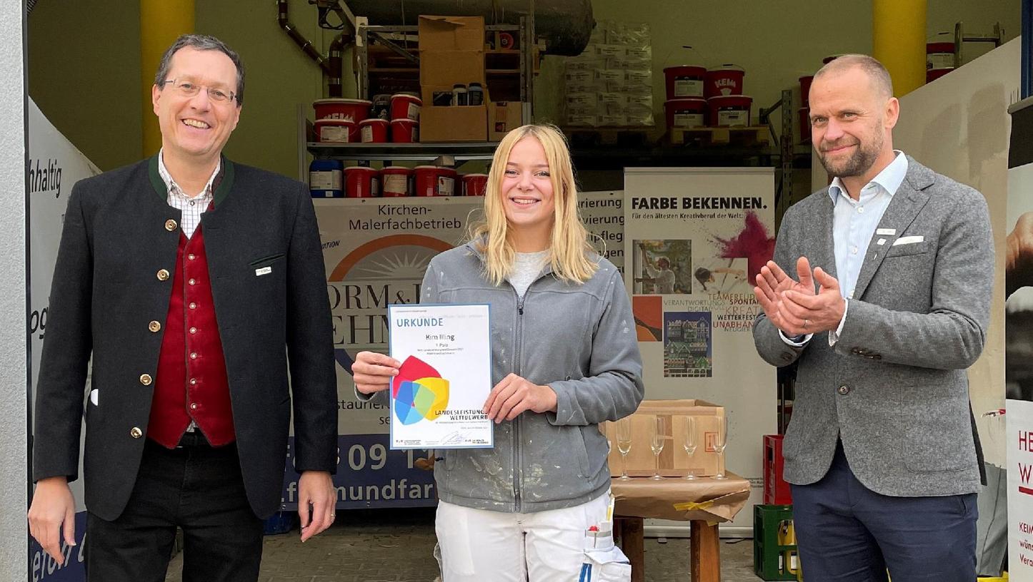 Kim Illing, Siegerin des Landeswettbewerbs der Maler, erhielt den Preis vom Geschäftsführer des Landesinnungsverbands des Bayerischen Maler- und Lackiererhandwerks, Claudius Wolfrum (links), sowie dem stellvertretenden Landesinnungsmeister Christopher Appis.