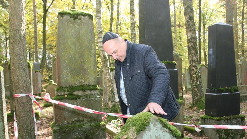 Joino Pollak vom Landesverband Israelitischer Kultusgemeinden in Bayern inspiziert einen Grabstein.