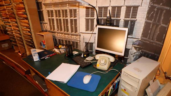 Unkaputtbar: Blick auf einen Arbeitstisch im ehemals 4. Rang des Opernhauses, von wo aus heute beleuchtet wird. Das in der Mitte ist in der Tat ein Wählscheibentelefon. Büros im Staatstheater sind ebenfalls zum Teil fensterlos und auf dem Stand der 1960er Jahre.