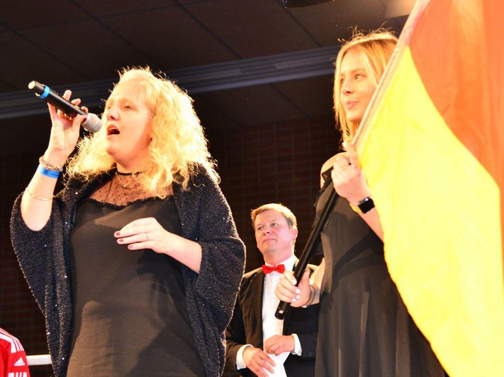 Die Pleinfelderin Alexandra Strobl sang vor den Finals der Frauen und der Männer im Boxring die deutsche Nationalhymne. Im Hintergrund Moderator Alexander Höhn.  