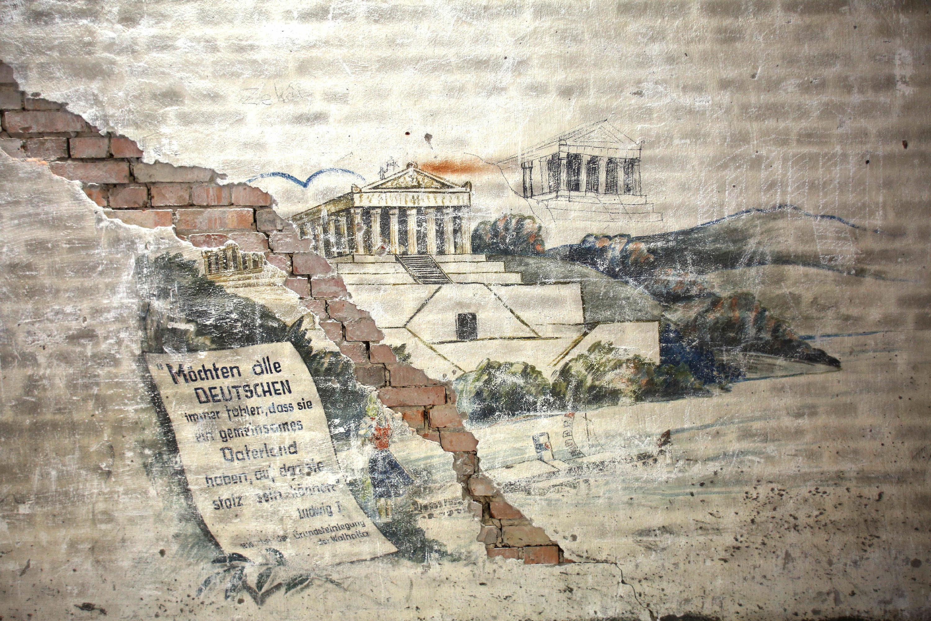 Doch auch andere Spuren aus lange zurückliegenden Tagen finden sich beim Rundgang. Mit Ausbruch des 2. Weltkriegs wurden die Arbeiten am Reichsparteitagsgelände und damit auch an der Kongresshalle eingestellt. In den letzten Kriegsjahren wurde auf dem Dach eine Flugabwehrkanone (Flak) installiert. Die Soldaten vertrieben sich die Zeit unter anderem damit, große Zeichnungen an die Wände zu malen ...