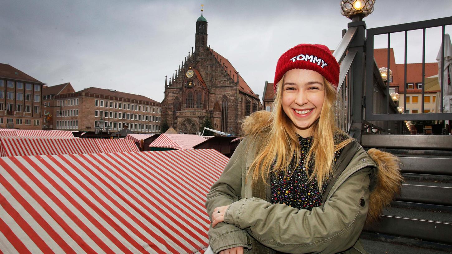 Das Christkind Teresa Windschall „ganz normal“ – vor allem die rote Mütze trägt sie im Herbst und Winter sehr gerne. Im Hintergrund wird gerade „ihr Markt“ aufgebaut.