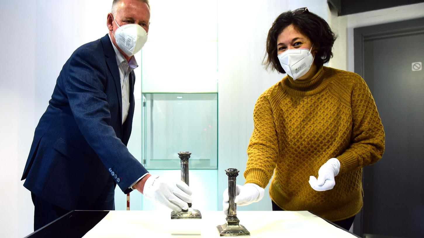 Museumsleiterin Daniela Eisenstein und OB Thomas Jung stellen die beiden Objekte in eine Vitrine im Treppenhaus des Jüdischen Museums