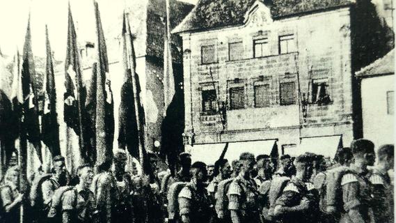 Teilnehmer eines NS-Aufmarsches Ende der 1930er Jahre auf dem Rathausplatz in Forchheim.
Teilnehmer eines NS-Aufmarsches Ende der 1930er Jahre auf dem Rathausplatz in Forchheim.
