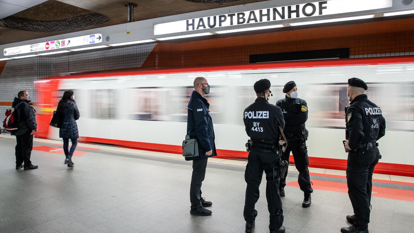 Polizisten und ein Mitarbeiter der VAG  machen am Hauptbahnhof einen Kontrollgang.