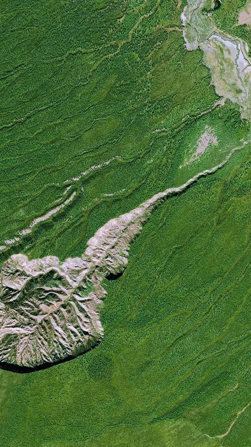 Der Batagaika-Krater in Sibirien ist mit einem Kilometer Breite und 100 Metern Tiefe der größte Permafrostkrater der Erde. Straßenbauarbeiten verletzten die Vegetationsschicht, der Boden taute auf und brach tief ein.  