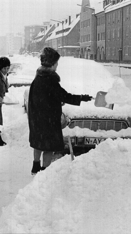 Mit Schaufel und Besen versuchten diese Autofahrerinnen, ihre Fahrzeuge zu befreien. Oft waren die Autos so von Schneebergen umgeben, dass sie kaum freizubekommen waren.