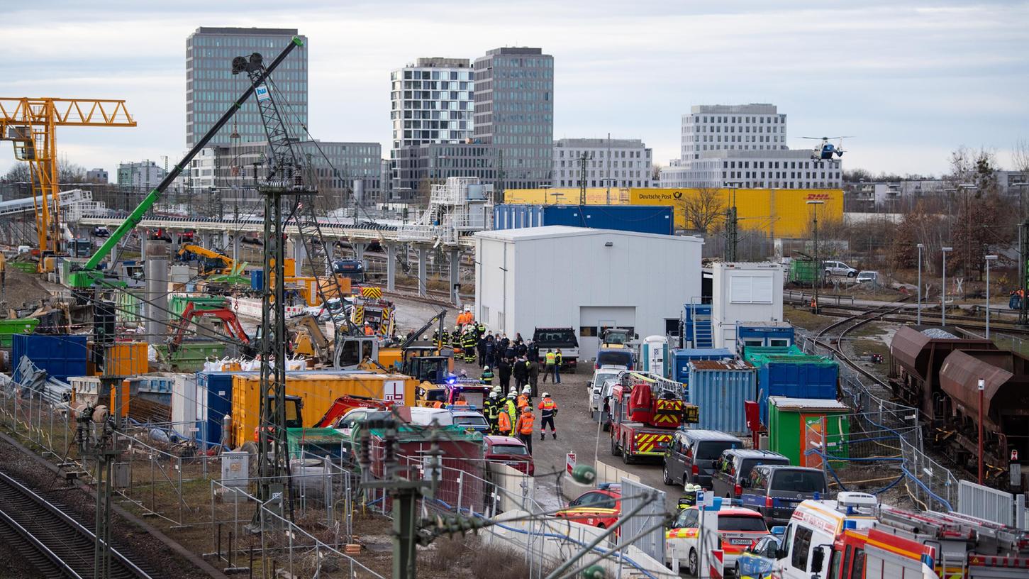 Feuerwehrleute, Polizisten und Bahnbedienstete stehen auf einem Bahngelände an der Donnersbergerbrücke. 