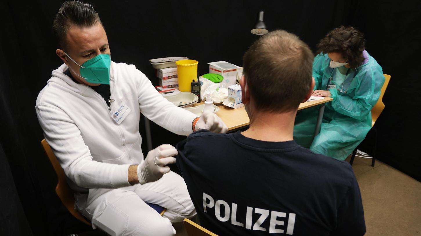 Ein Polizist in Nordrhein-Westfalen bekommt eine Booster-Impfung. In Bayern ist eine Debatte über die Tatsache aufgeflammt, dass 20 Prozent der Beamten noch nicht vollständig oder gar nicht geimpft sind.