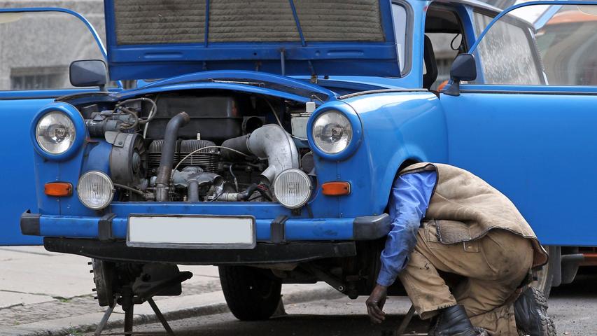 Ein Mann repariert seinen Trabant 601 auf einer Straße in Leipzig. Gut 33.000 "Trabis" rollten im Jahr 2010 über die deutschen Straßen. Zum Vergleich: Zur Wiedervereinigung waren es noch knapp eine Million Fahrzeuge.