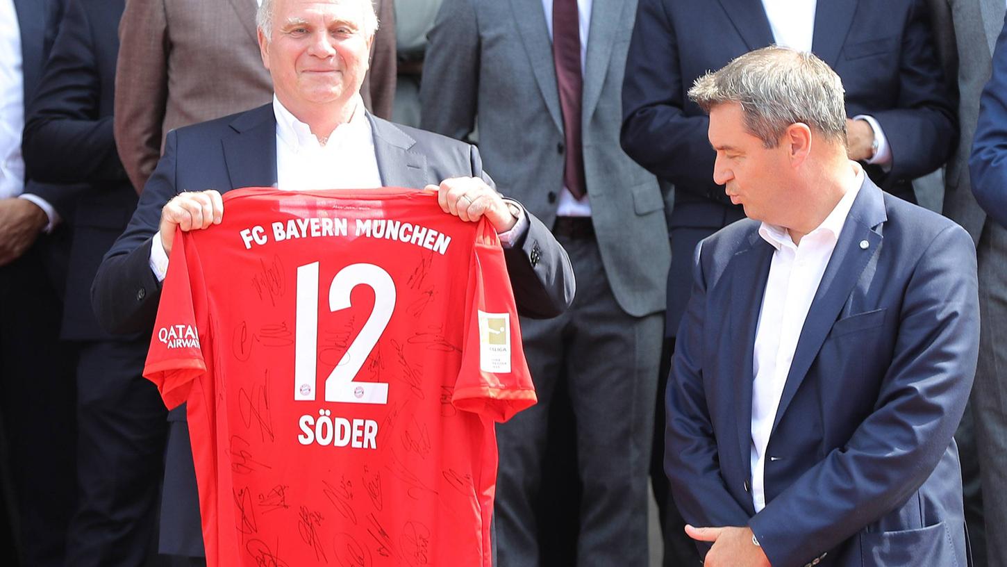 Welch ein herausragender Schauspieler: Markus Söder scheint sich über das Geschenk von Uli Hoeneß zu freuen. 