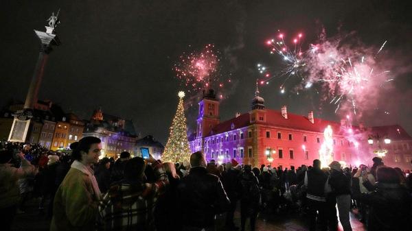 Menschen zünden ein Feuerwerk zur Feier des neuen Jahres in Warschau.