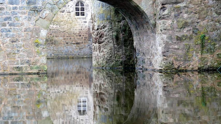 Das glatte Wasser verdoppelt den Bogen bei Schloss Sommersdorf zu einer imposanten Durchfahrt.