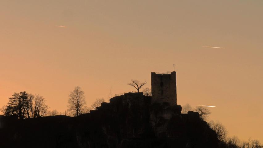 Die Silhouette der Burgruine Neideck im Abendlicht.